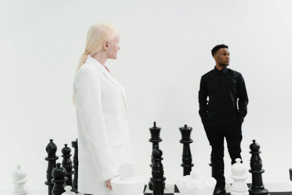 Two adults engage with a life-sized chess set, symbolizing strategy and leadership.